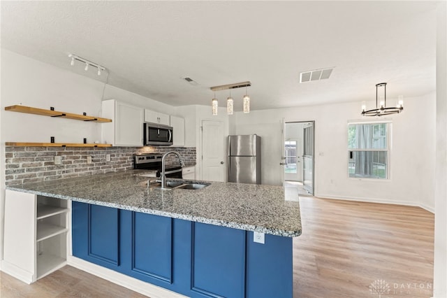 784 Marshall Dr, Xenia, OH 45385 - kitchen featuring stainless steel appliances, open shelves, a peninsula, light wood-style flooring, and backsplash