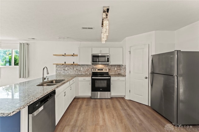 784 Marshall Dr, Xenia, OH 45385 - kitchen featuring stainless steel appliances, open shelves, light wood finished floors, a peninsula, and white cabinets