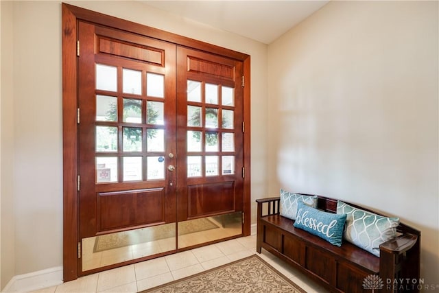 doorway to outside with light tile patterned floors and baseboards