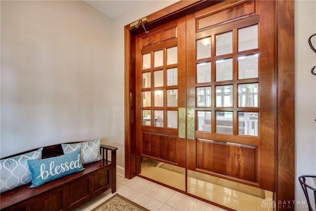 entryway with light tile patterned floors and baseboards