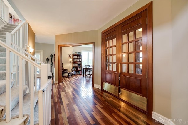 entrance foyer featuring stairs, baseboards, and dark wood-style floors