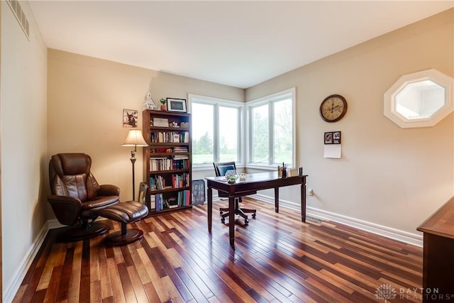 office space with baseboards, visible vents, and dark wood-style floors