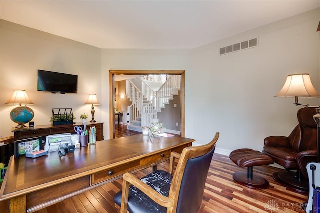 office space with visible vents, wood finished floors, and baseboards