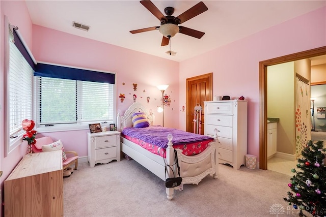 bedroom featuring light colored carpet, connected bathroom, visible vents, and a ceiling fan