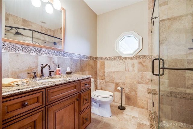 full bathroom with tile walls, toilet, wainscoting, a shower stall, and vanity