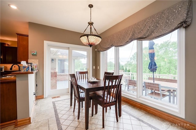 dining area featuring baseboards, light tile patterned floors, and plenty of natural light