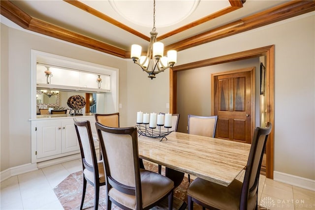 dining room with a chandelier, a raised ceiling, baseboards, and light tile patterned floors