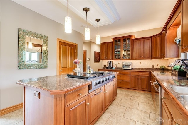 kitchen with glass insert cabinets, stainless steel appliances, brown cabinetry, pendant lighting, and a kitchen island