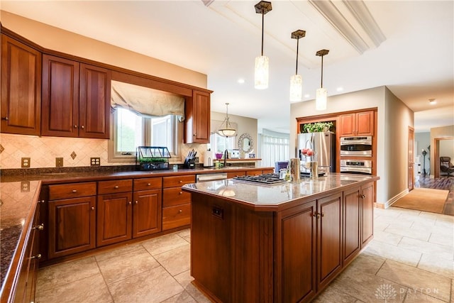 kitchen featuring brown cabinets, backsplash, hanging light fixtures, a kitchen island, and appliances with stainless steel finishes