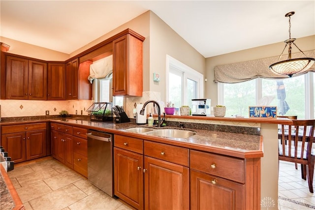 kitchen with a sink, a peninsula, brown cabinets, backsplash, and stainless steel dishwasher