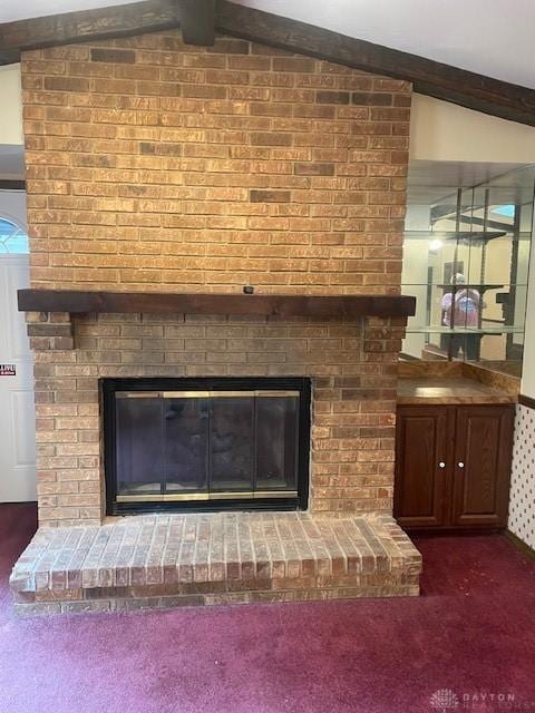 details with a fireplace, beam ceiling, and carpet floors