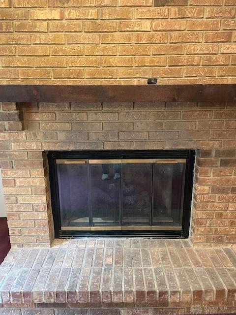 interior details featuring a brick fireplace