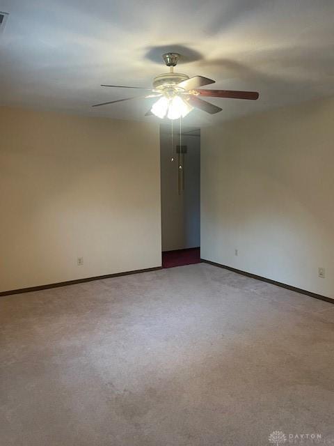 empty room featuring baseboards, visible vents, ceiling fan, and carpet floors