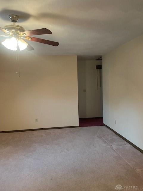 carpeted empty room featuring baseboards and a ceiling fan