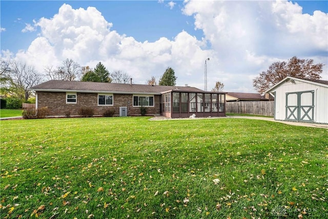 1824 Scotch Pine Dr, Beavercreek, OH 45432 - rear view of property featuring a sunroom, brick siding, a lawn, and a shed