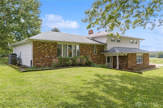 1572 State Route 380, Wilmington, OH 45177 - view of front facade with a front lawn, brick siding, a chimney, and central AC
