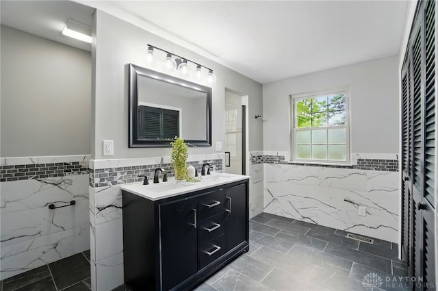 5741 Hithergreen Dr, Washington Twp, OH 45429 - bathroom with tile walls, wainscoting, double vanity, a marble finish shower, and marble look tile flooring