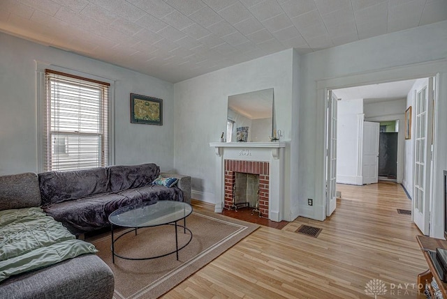 4103 Whetsel Ave, Cincinnati, OH 45227 - living area featuring light wood finished floors, a brick fireplace, and baseboards