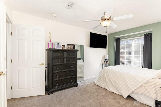 bedroom with light carpet, a ceiling fan, and baseboards