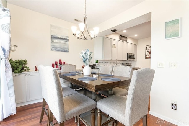 dining space featuring a chandelier, wood finished floors, recessed lighting, and baseboards