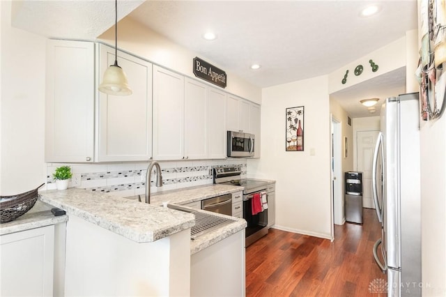 kitchen with appliances with stainless steel finishes, decorative backsplash, dark wood-style flooring, a peninsula, and recessed lighting
