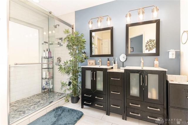 full bathroom featuring a shower stall, tile patterned floors, and two vanities