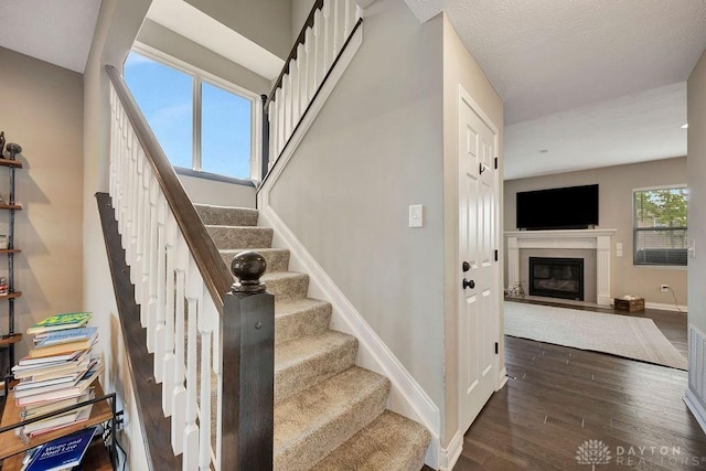 1737 Red Clover Dr, Lebanon, OH 45036 - stairway with wood finished floors, baseboards, and a glass covered fireplace