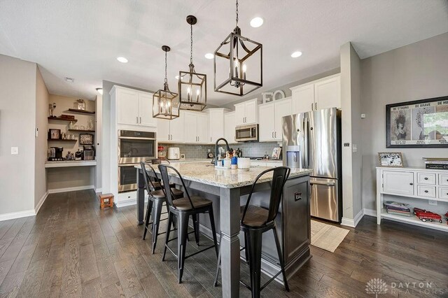 1737 Red Clover Dr, Lebanon, OH 45036 - kitchen featuring appliances with stainless steel finishes, a chandelier, dark wood-type flooring, white cabinets, and pendant lighting