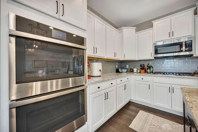 1737 Red Clover Dr, Lebanon, OH 45036 - kitchen featuring stainless steel appliances, white cabinetry, dark wood-type flooring, backsplash, and light stone countertops