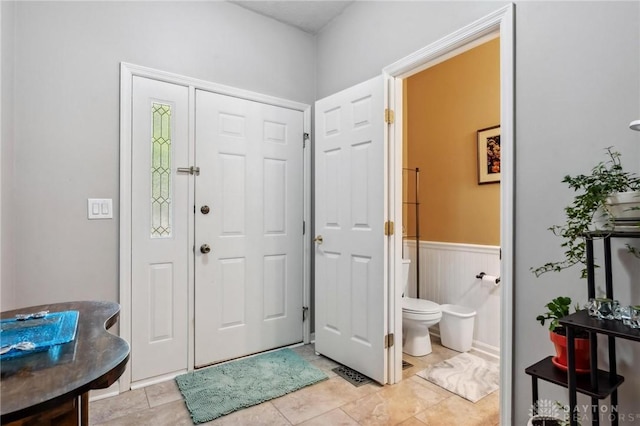 foyer with a wainscoted wall