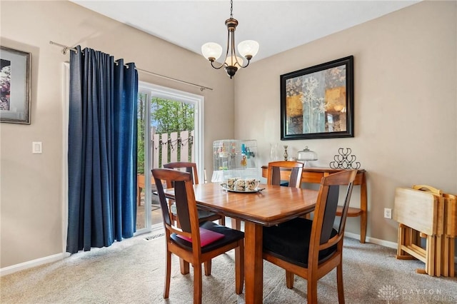 carpeted dining area with baseboards and a chandelier