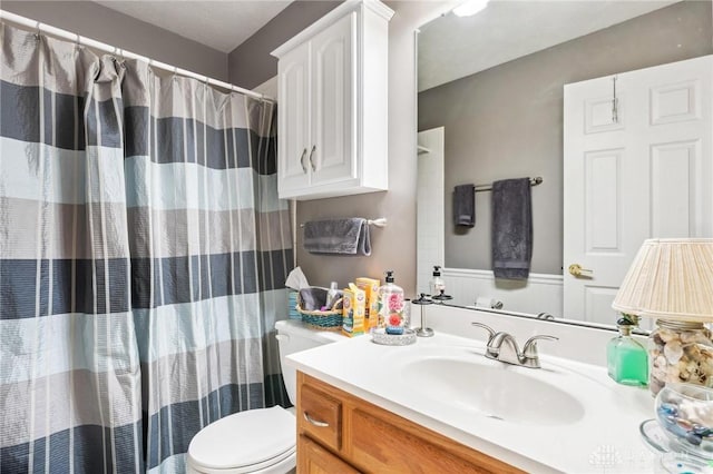 full bathroom with vanity, toilet, and curtained shower