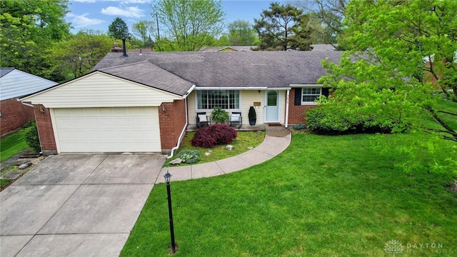 ranch-style home with brick siding, an attached garage, concrete driveway, a front lawn, and roof with shingles