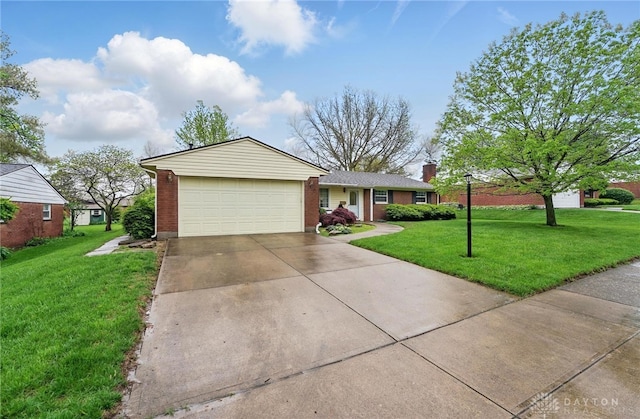single story home with concrete driveway, a front lawn, an attached garage, and brick siding