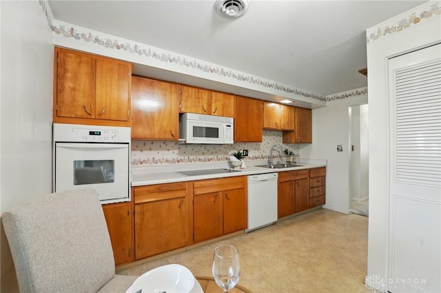 kitchen featuring white appliances, a sink, light countertops, brown cabinetry, and decorative backsplash