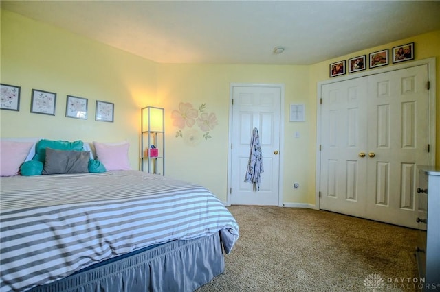 carpeted bedroom featuring baseboards and a closet