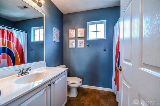 full bathroom featuring plenty of natural light, vanity, toilet, and baseboards