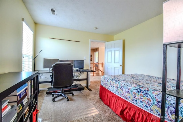 bedroom with carpet floors and an office area