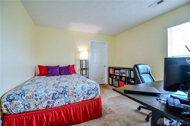 carpeted bedroom with a desk