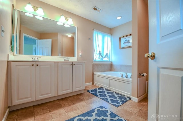 full bathroom with a bath, double vanity, tile patterned floors, and baseboards