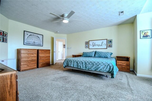 carpeted bedroom with a textured ceiling, ceiling fan, and baseboards