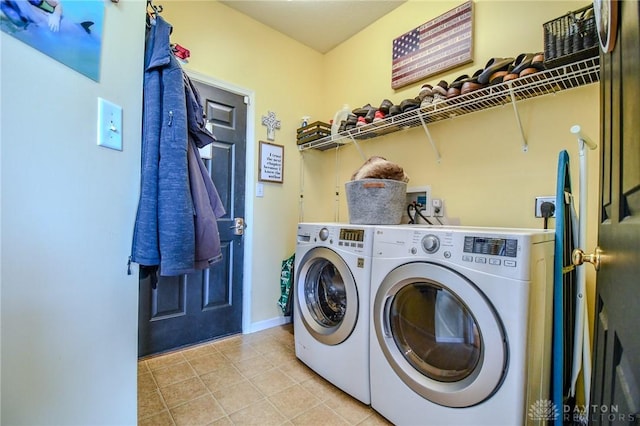 laundry room featuring washing machine and clothes dryer, light tile patterned flooring, and baseboards
