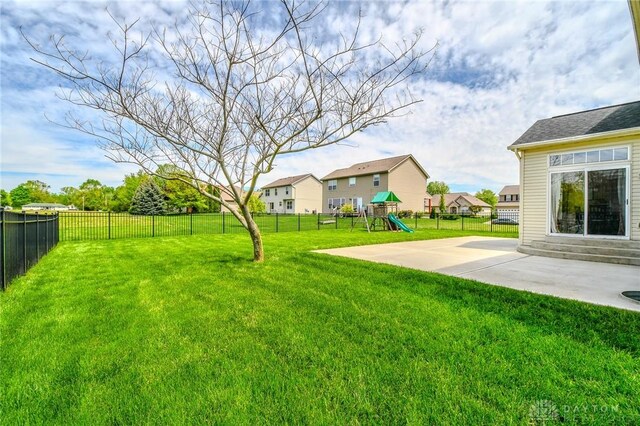 view of yard with a playground, a patio, and a residential view