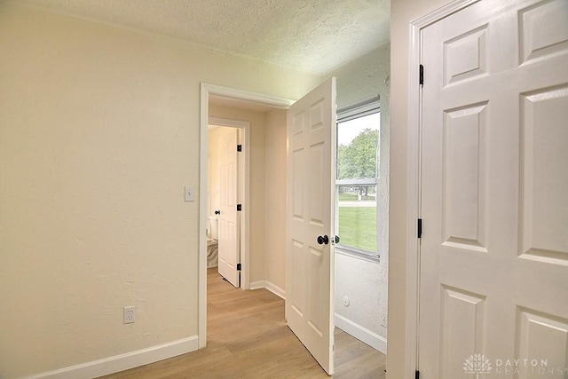 3417 Beechgrove Rd, Moraine, OH 45439 - hallway featuring light wood-style floors, a textured ceiling, and baseboards