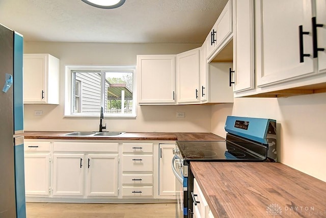 3417 Beechgrove Rd, Moraine, OH 45439 - kitchen featuring electric range, butcher block counters, a sink, white cabinetry, and light wood-style floors