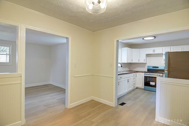 3417 Beechgrove Rd, Moraine, OH 45439 - kitchen with appliances with stainless steel finishes, light wood-type flooring, white cabinetry, crown molding, and a textured ceiling