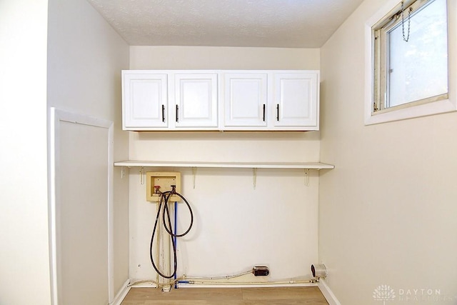 3417 Beechgrove Rd, Moraine, OH 45439 - laundry room featuring hookup for a washing machine, cabinet space, wood finished floors, and baseboards
