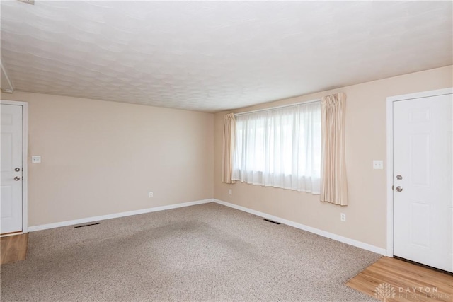 3762 Waterbury Dr, Kettering, OH 45439 - unfurnished living room featuring baseboards and light colored carpet