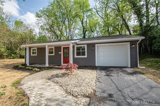 single story home featuring covered porch, driveway, and a garage