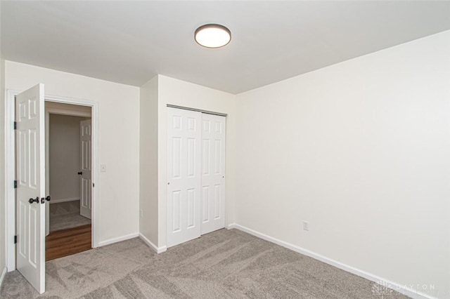 unfurnished bedroom featuring carpet, a closet, and baseboards
